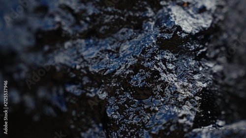 Dark carbon fossil mineral with rough texture forming an abstract background, representing energy, industrial resources, and non renewable fuel