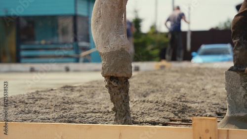 Fotografía Concrete pump hose pouring fresh cement mix into a prepared wooden formwork for