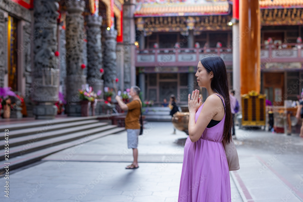 Obraz premium Pregnant woman praying inside temple in taiwan