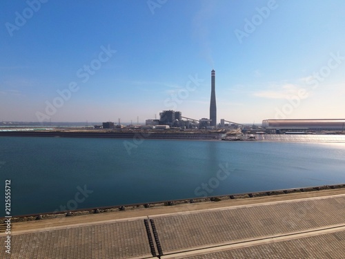 Fotografie Aerial view of Matarbari Coal Power Plant with its tall chimney and industrial facilities along the coast with concrete embankments in Cox's Bazar District, Chittagong Division, Bangladesh