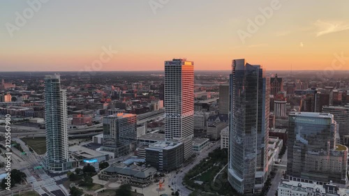 Close Aerial View of Milwaukee Downtown Skyscrapers at Sunset” Close aerial view of downtown Milwaukee, Wisconsin skyscrapers at sunset, with warm light illuminating one high-rise tower 