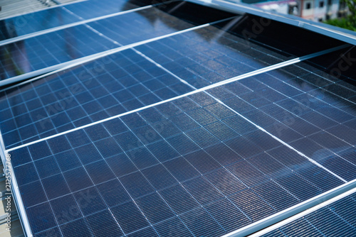 фотографія Endless dark rows of finished photovoltaic panels dominate the industrial roofscape, silent on a commercial factory rooftop photovoltaic construction site in Asia