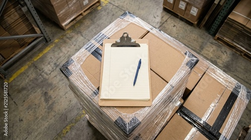 Compliance officer's clipboard resting on a refrigerated pallet corner during a lengthy inspection.