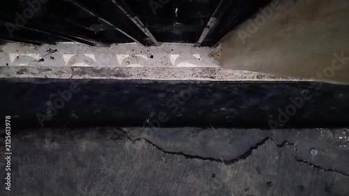 Angle view of fast-flowing rainwater inside a concrete drain channel on a rainy afternoon