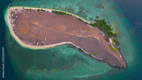 Aerial view of Pulau Kenawa surrounded by turquoise waters and coral reefs in Poto Tano, West Nusa Tenggara, Indonesia.