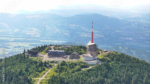 Aerial view of Lysa hora summit with its telecommunications tower, mountain huts, and dense pine forests in the Beskydy mountains in Krasna, Moravian-Silesian Reg, Czechia.