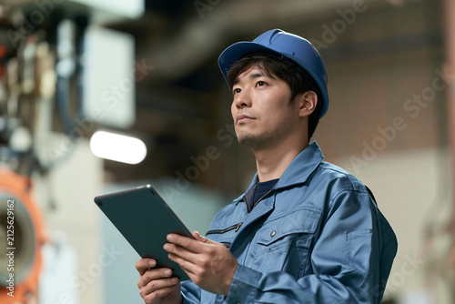 Obraz na płótnie 工場の設備をタブレットで点検する日本人男性作業員