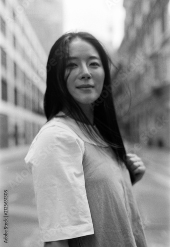 Canvas Print Asian woman walking city street with film grain