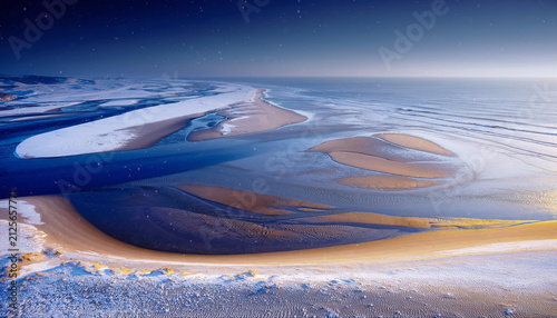 Serene Winter Beach Landscape with Snowy Dunes and Calm Sea under Starry Night Sky