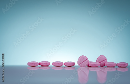 Canvastavla Pink pharmaceutical tablets on reflective surface, healthcare background