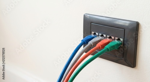 Colorful Ethernet Cables Connected to Wall Outlet in Modern Home Office Setting