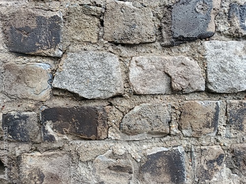 Fotografie Old damaged stone wall surface texture, closeup view