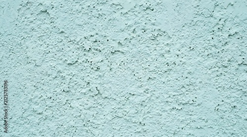 Light blue textured concrete wall background, rough stucco surface with uneven pattern