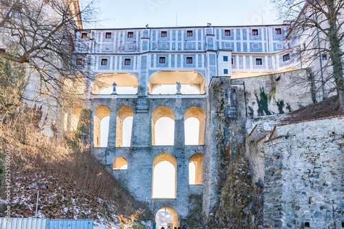 Multi-arched Cloak Bridge of Cesky Krumlov Castle viewed from below under clear blue sky, Czechia, UNESCO World Heritage Site