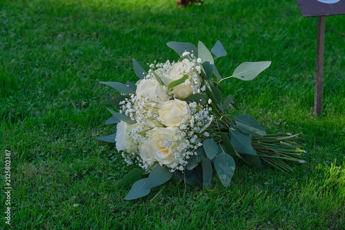 Romantic bunch of white roses on a grassy background, ideal for bridal scenes, wedding decor, or romantic summer outdoor photography with copy space.