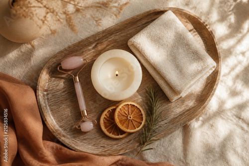 Self-care flat lay with rose quartz roller and candle