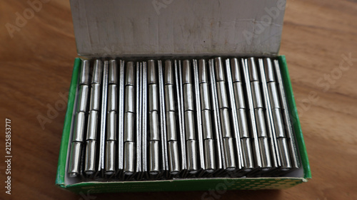 Fotografie Close Up Steel Butt Hinges Packed Inside Open Cardboard Box on Wooden Surface