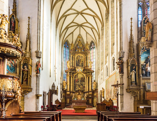 Interior of Gothic Church of St. Vitus with ornate main altar and vaulted ceiling in Cesky Krumlov, Czechia, UNESCO World Heritage Site