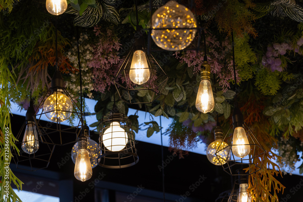 Obraz premium Charming string lights dangle through lush foliage in shop.