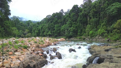Drone low flyover above rapids on Sungai Tembeling surrounded by primary tropical rainforest, Al-Sultan Abdullah Royal Tiger Reserve, Pahang, Malaysia