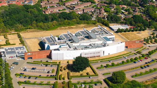 Aerial view of the Nursling Industrial Estate featuring a large modern office building with solar panels, surrounded by parking lots and green spaces in Nursling, England, United Kingdom.