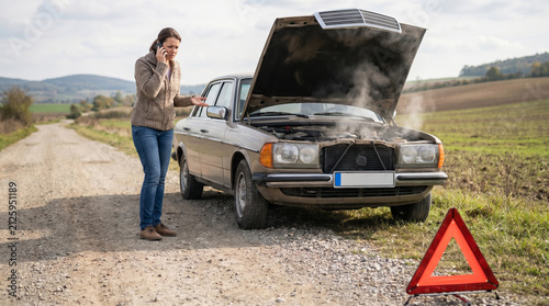 Woman Calling for Help Beside A Steaming Car with Hood Open on Rural Road