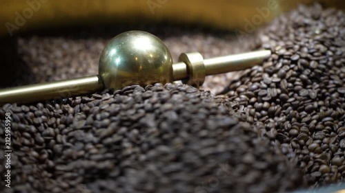 Roasted Coffee Bean Pile: A close-up shot reveals a rich pile of freshly roasted coffee beans, with a golden scoop resting on top, hinting at the brewing process.