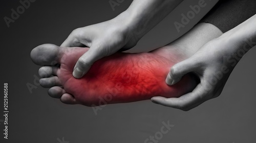 Person massaging sore foot highlighting chronic plantar fasciitis pain with red digital overlay effect