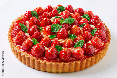 Tarte aux fraises sur fond blanc, pâte sablée dorée, crème pâtissière et fraises fraîches brillante en cercles concentriques, avec feuilles de menthe