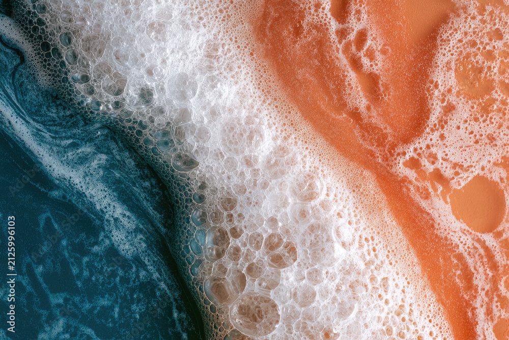Fototapeta premium Abstract close-up of blue, white, and orange foamy liquid textures