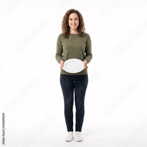 Smiling young woman holding a white oval plate against a clean white background.
