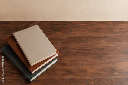 Stack of three blank books on a wooden table with copy space