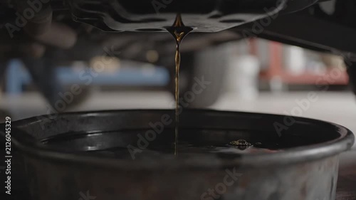 Car oil draining into pan with close up.