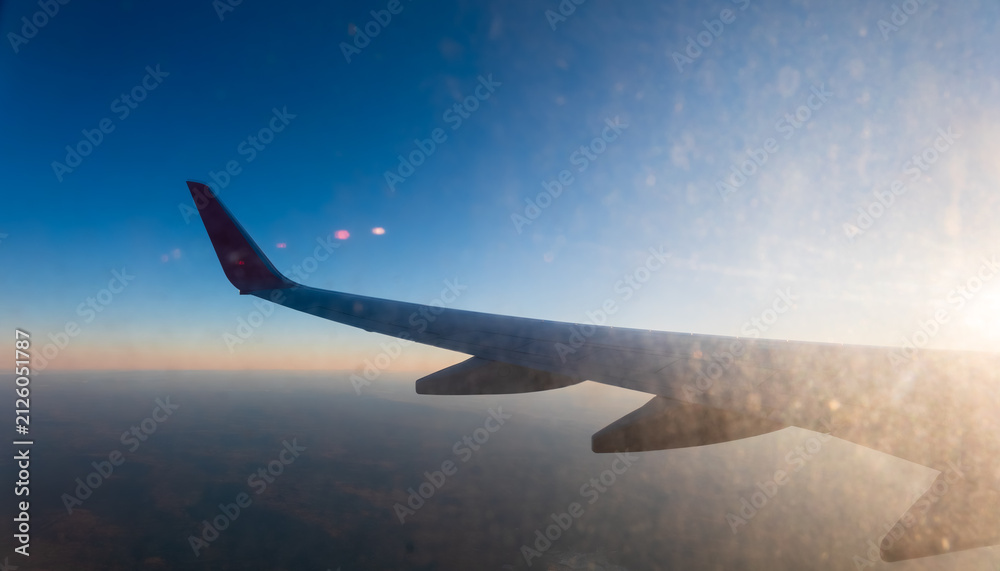 Fototapeta premium View on sunset and airplane wing from the inside