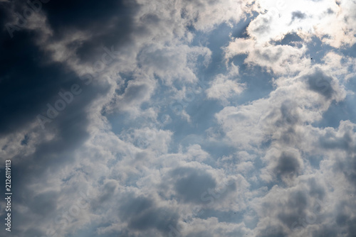 Plakat Dramatic cloud formations with sunlight breaking through in a blue sky during daytime