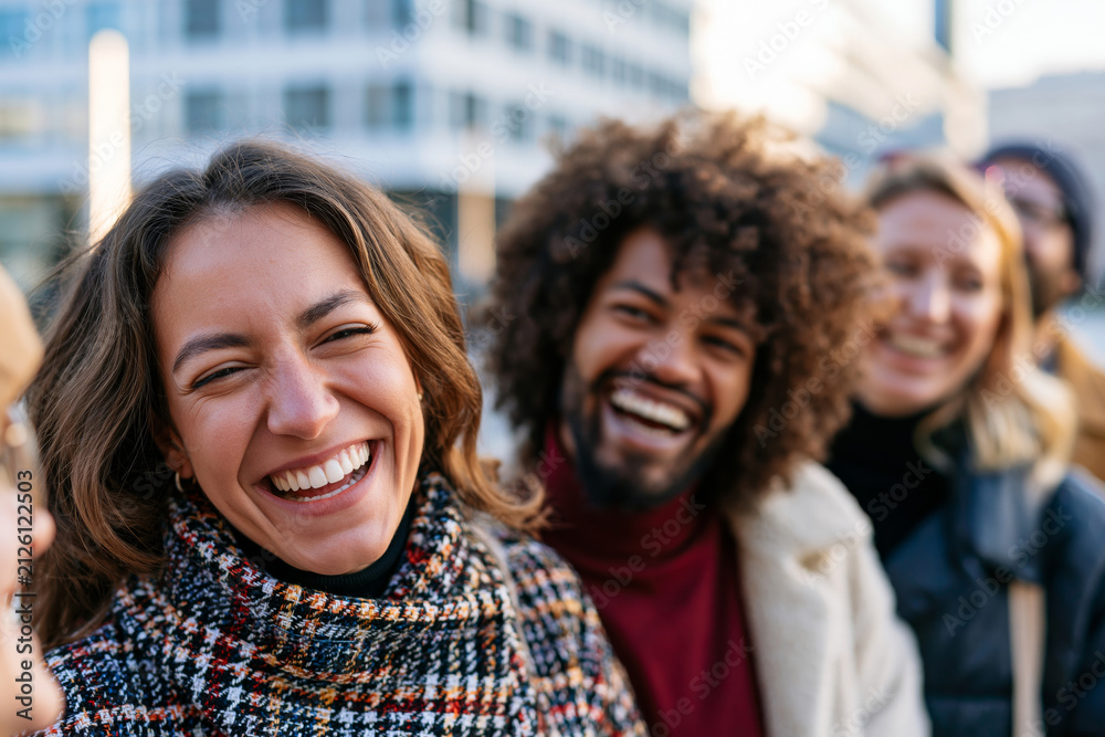 Obraz premium Diverse group of friends spending time together in a modern city square, genuine laughter and connection, bright natural sunlight, realistic lifestyle scene