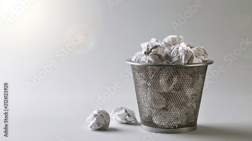 Wastebasket overflowing with crumpled paper, symbolizing discarded ideas, mistakes, and the creative process