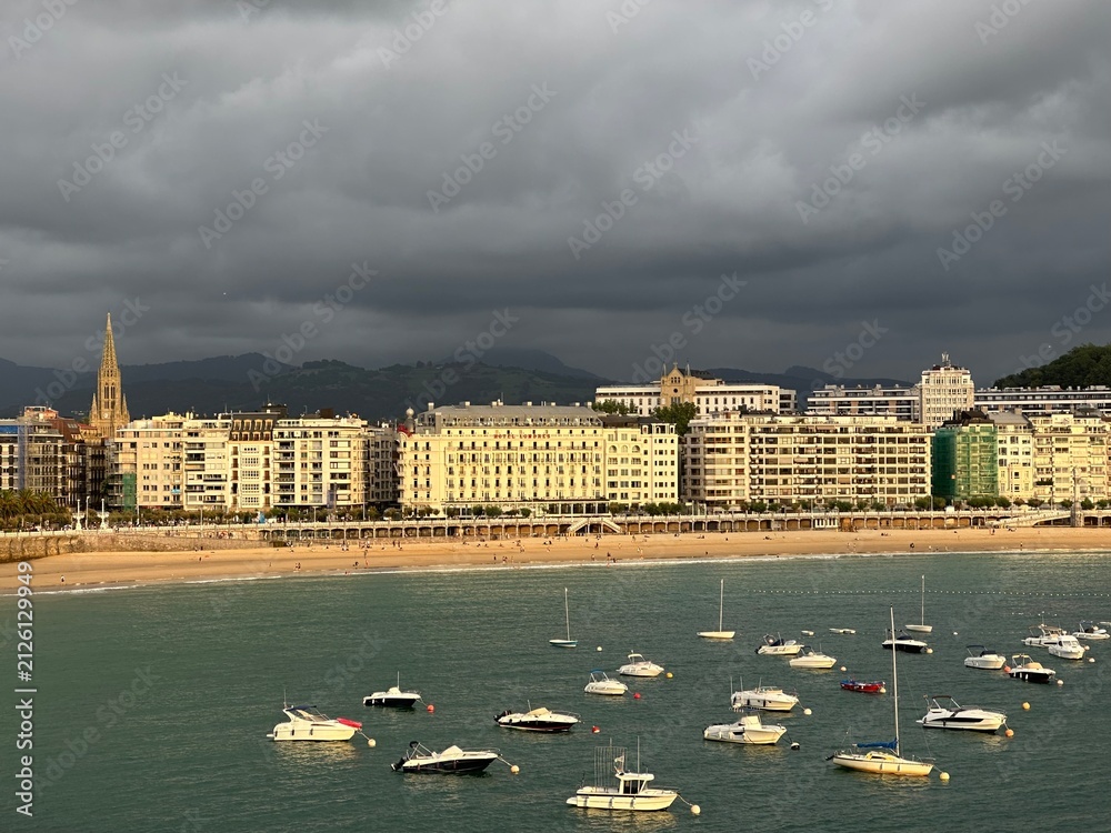 Fototapeta premium Coastal town San Sebastian with beach and boats in La Concha Bay, Basque Country, Spain, July 2023