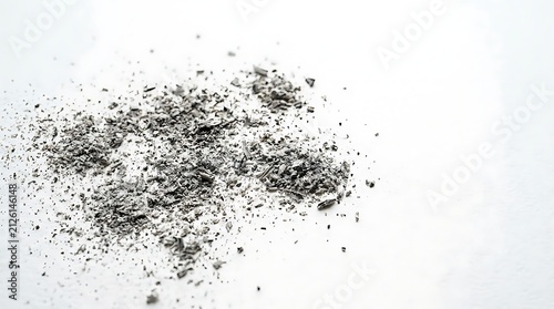 Scattered Gray Burnt Ash and Charcoal Particles on a Minimalist White Surface Background Close Up
