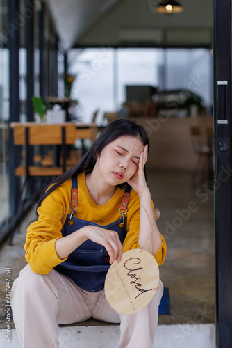 фотографія Stressed small business owner closing cafe due to financial struggles and exhaus