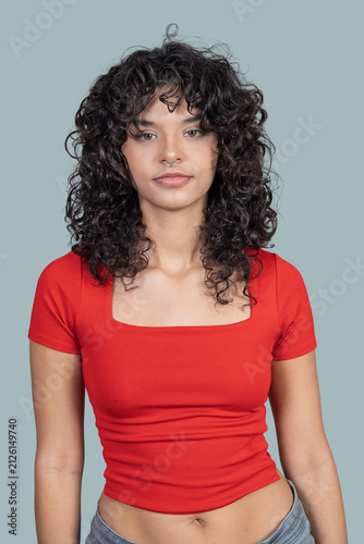Young woman confidently showing her curly hair and septum piercing