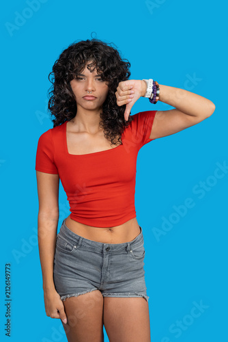 Bild auf Leinwand Young woman giving thumbs down showing disapproval