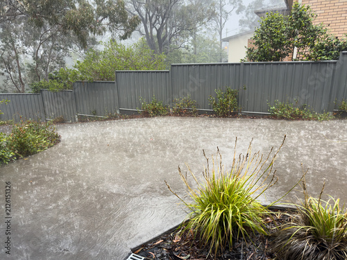 Extremely heavy rain splashing and running like a river down a concrete driveway