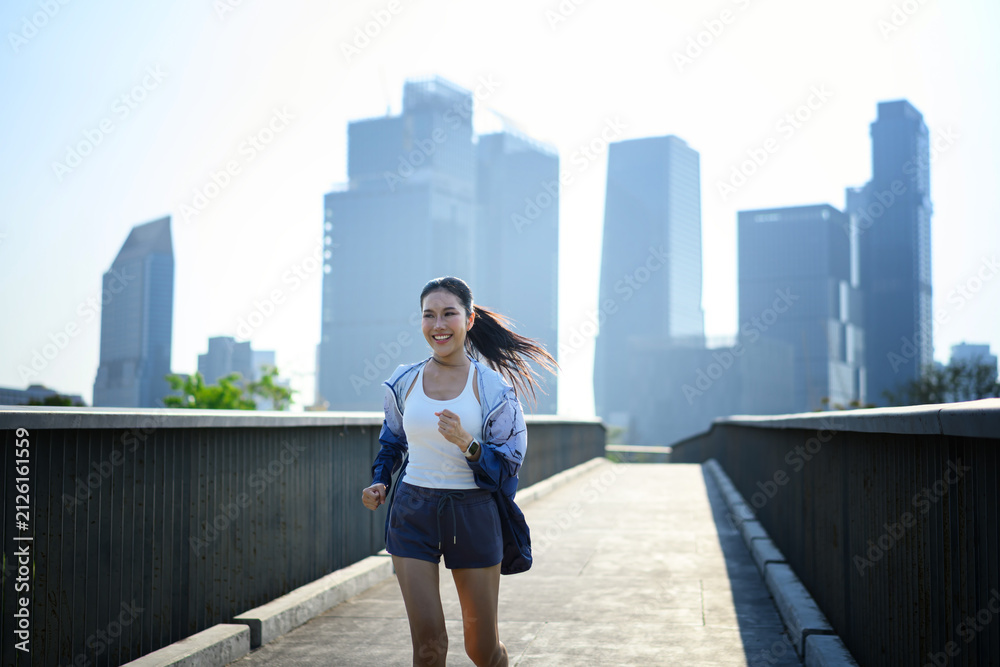 Fototapeta premium Joyful runner in city sunlight, active urban lifestyle momentum.