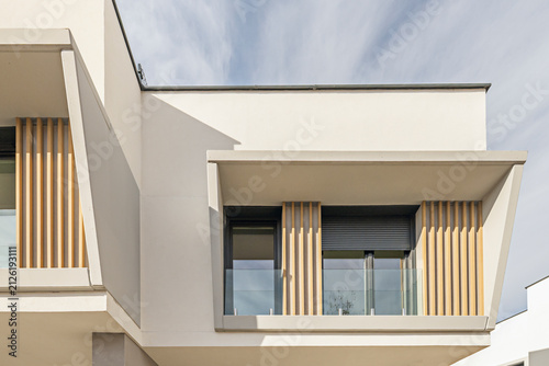 Quadro su tela Close-up angular view of contemporary building facade with wooden slats, glass r