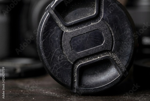Macro close up of a black plastic camera lens cap showing fine micro-scratches and dust