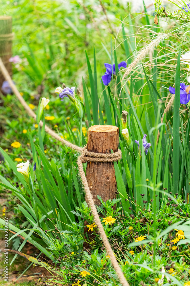 Obraz premium Pile of sharp wood, wooden fence posts in flower garden
