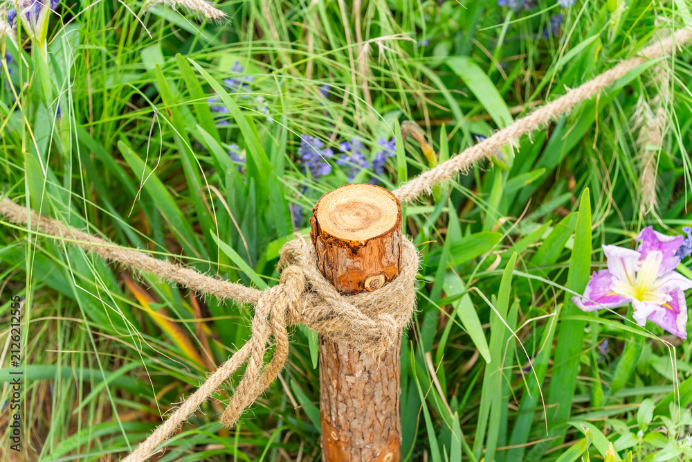 Obraz premium Pile of sharp wood, wooden fence posts in flower garden