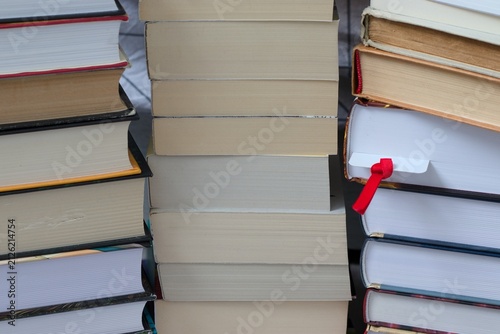Obraz na płótnie Collection of stacked books with a red bookmark representing education learning