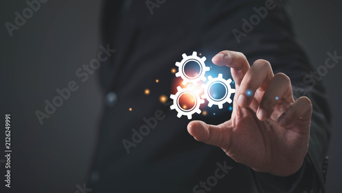 Business professional interacting with digital gears, representing business process automation, workflow optimization, system integration, operational efficiency, digital transformation, innovation.